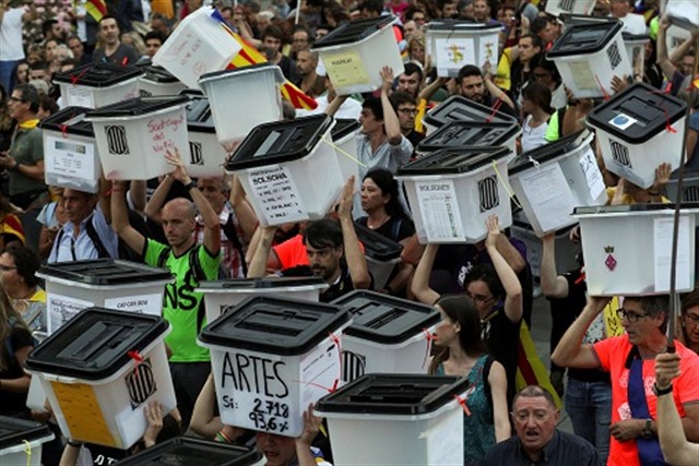 Votantes del 1-O con las urnas.