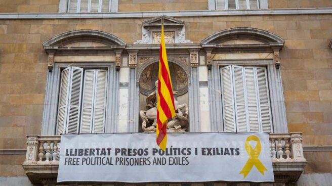 Un grupo de personas retira el lazo amarillo del Ayuntamiento de Barcelona