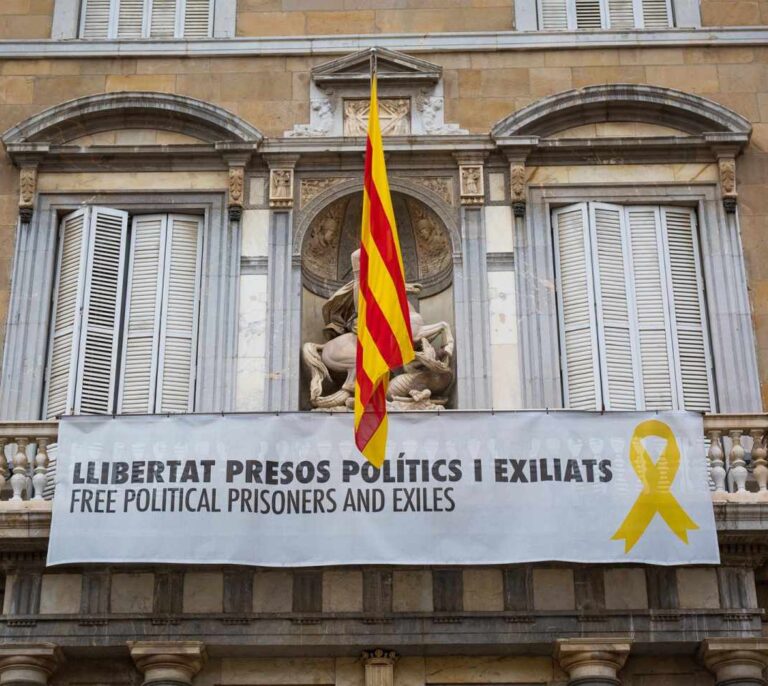 Un grupo de personas retira el lazo amarillo del Ayuntamiento de Barcelona