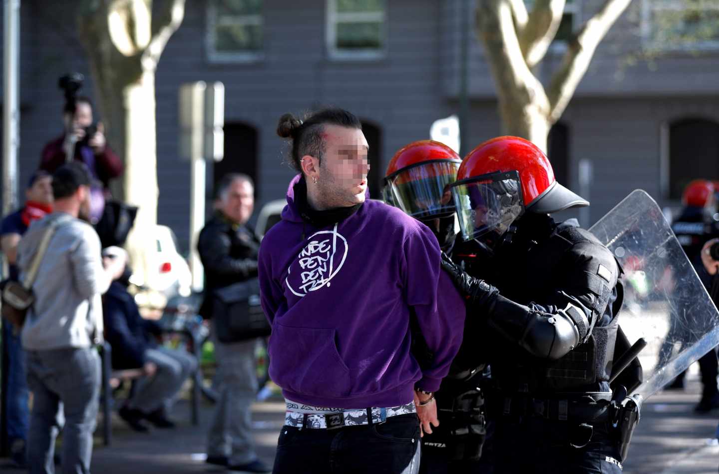 Un joven es detenido por agentes de la Ertzaintza durante la concentración que un centenar de personas han llevado a cabo ante el Palacio Euskalduna de Bilbao, donde esta tarde participa el líder de Vox, Santiago Abascal en un acto electoral.