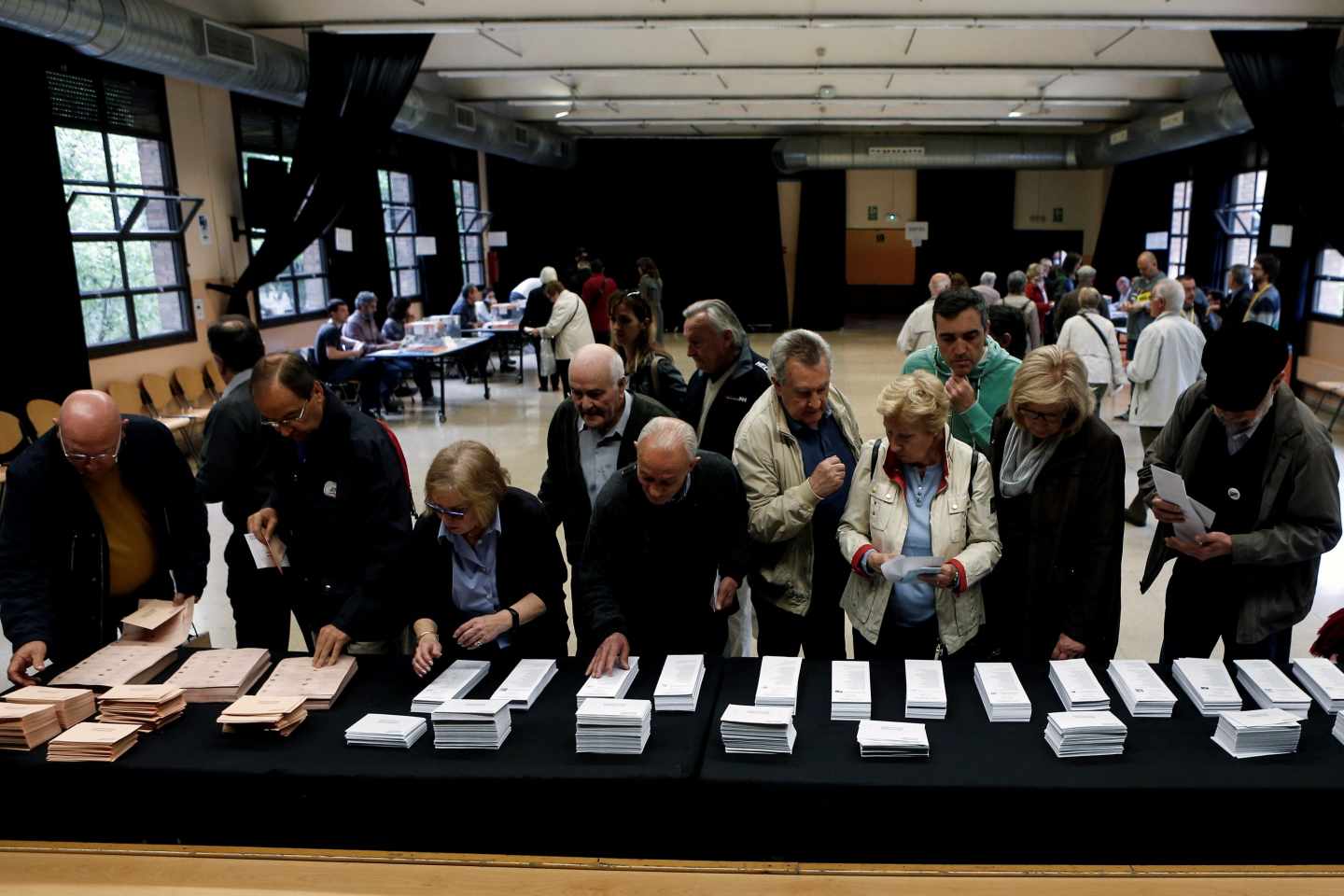 Los colegios electorales han abierto sus puertas a las 09:00 horas para recoger el voto de los casi 36,9 millones de electores que decidirán este domingo en los comicios generales el reparto de los 350 escaños del Congreso de los Diputados y los 208 del Senado durante la próxima legislatura.Tras la constitución de las mesas a las ocho de la mañana con la comprobación de que estaban los miembros necesarios y la lectura de los manuales, a las nueve de la mañana los electores han comenzado a acudir a las urnas, en una jornada que estará marcada por el sol y con temperaturas, en general, al alza en casi todo el país. En la foto,un grupo de personas eligen su papeleata en el Centro Cívico de La Sedeta.