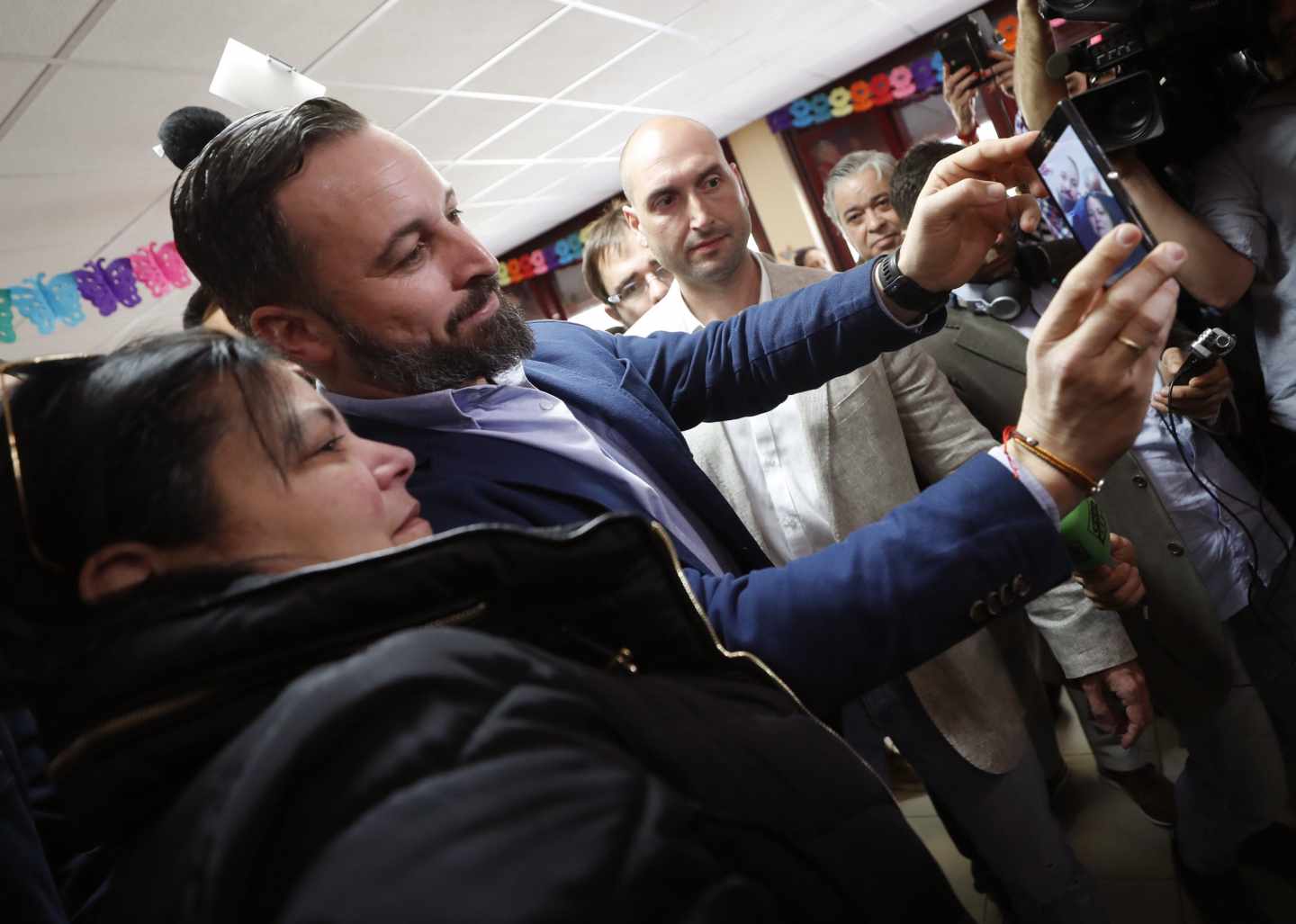 El presidente de VOX y candidato a la presidencia del Gobierno, Santiago Abascal,se hace una foto con una simpatizante tras depositar su voto en el Colegio Público Pinar del Rey,