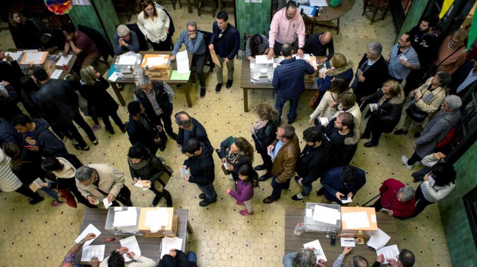 Numerosas personas hacen cola para votar este domingo en el colegio electoral de la Universidad de Barcelona