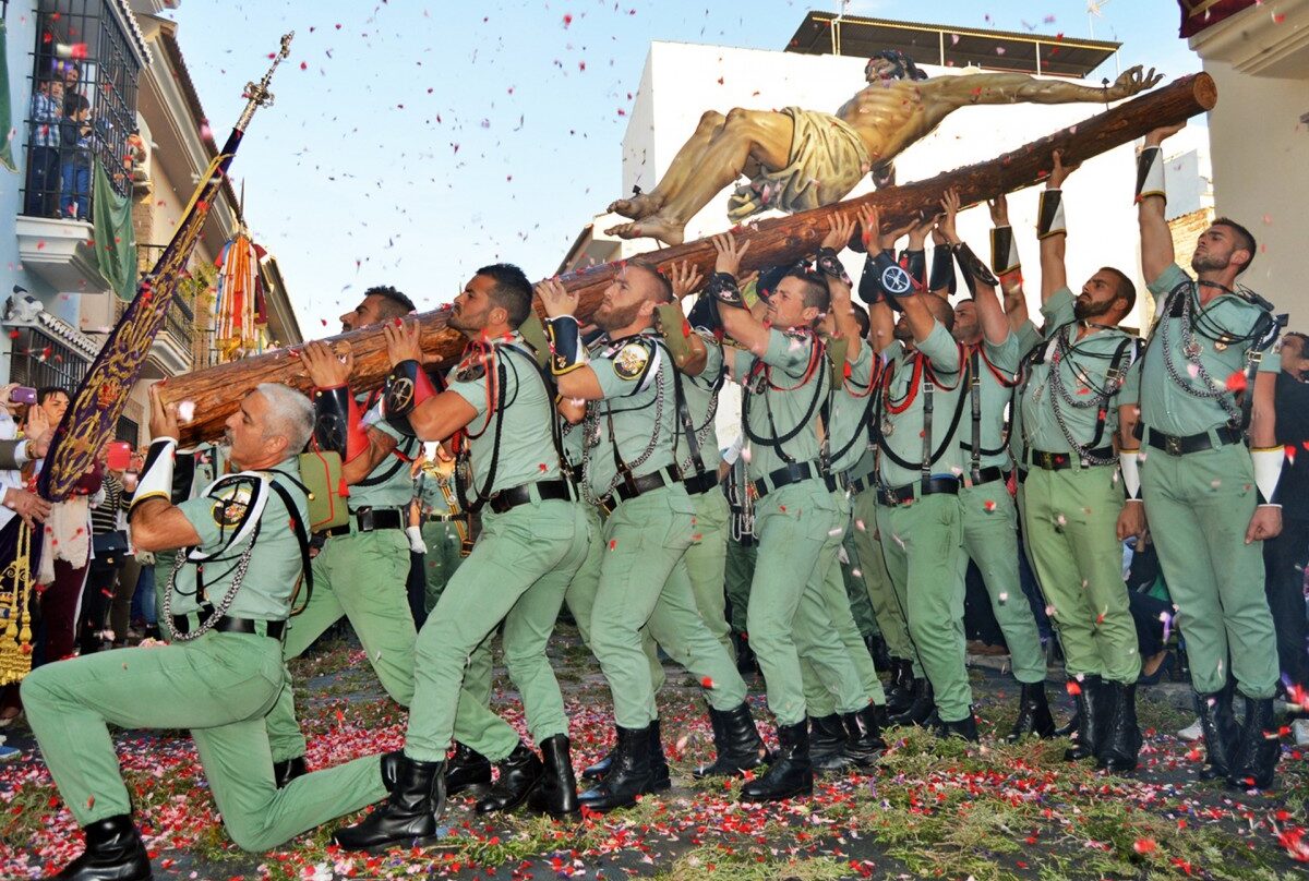 Un grupo de legionarios levanta al Cristo de Mena en Málaga.