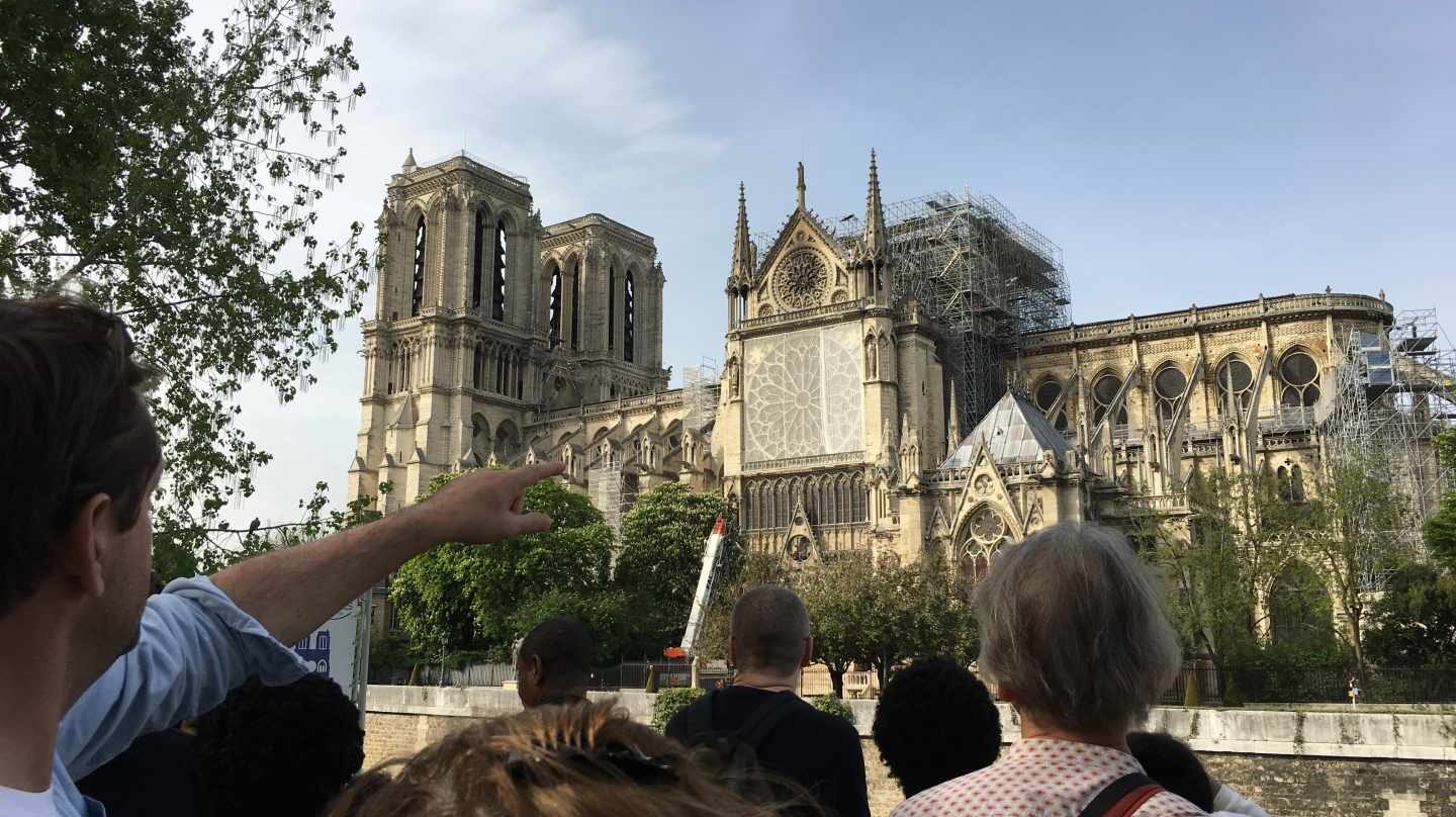 Los turistas se agolpan en el exterior de Notre-Dame para ver el efecto del incendio.