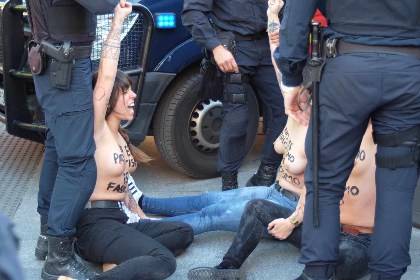 Las activistas de Femen gritan ante los agentes de la Policía.