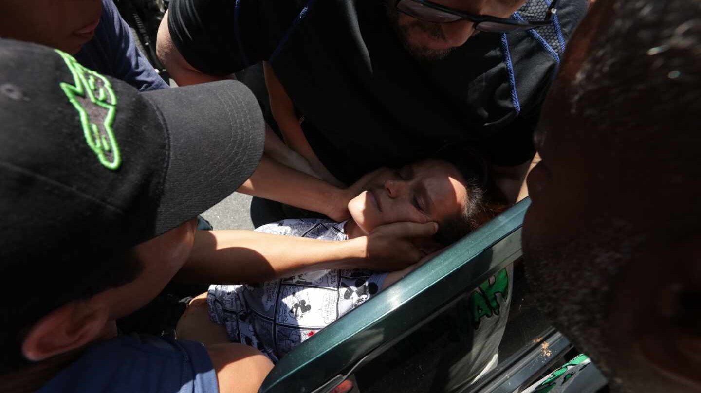 Manifestantes trasladan a una mujer herida de bala en Caracas, Venezuela.