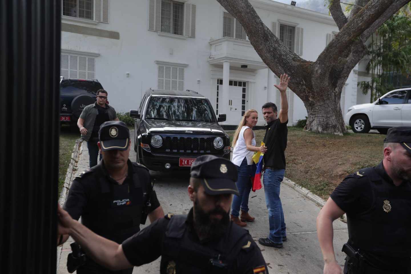 Leopoldo López saluda junto a Lilian Tintori detrás de policías españoles en la embajada.