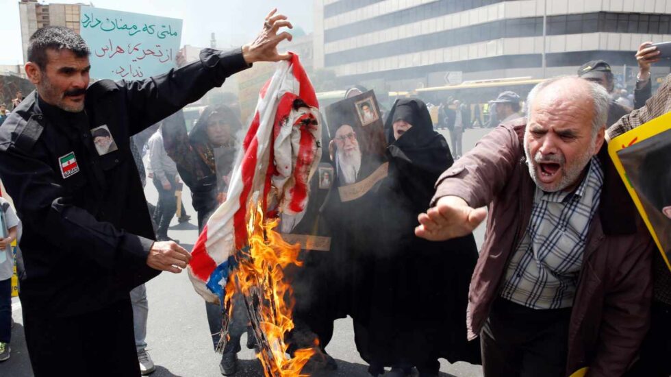 Manifestantes iraníes queman banderas de EEUU en Teherán.