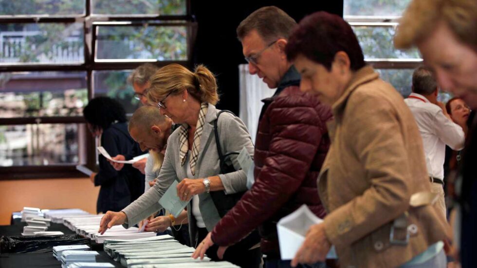 Varios ciudadanos escogen sus papeletas electorales en el Centre Cívic La Sedeta de Barcelona.