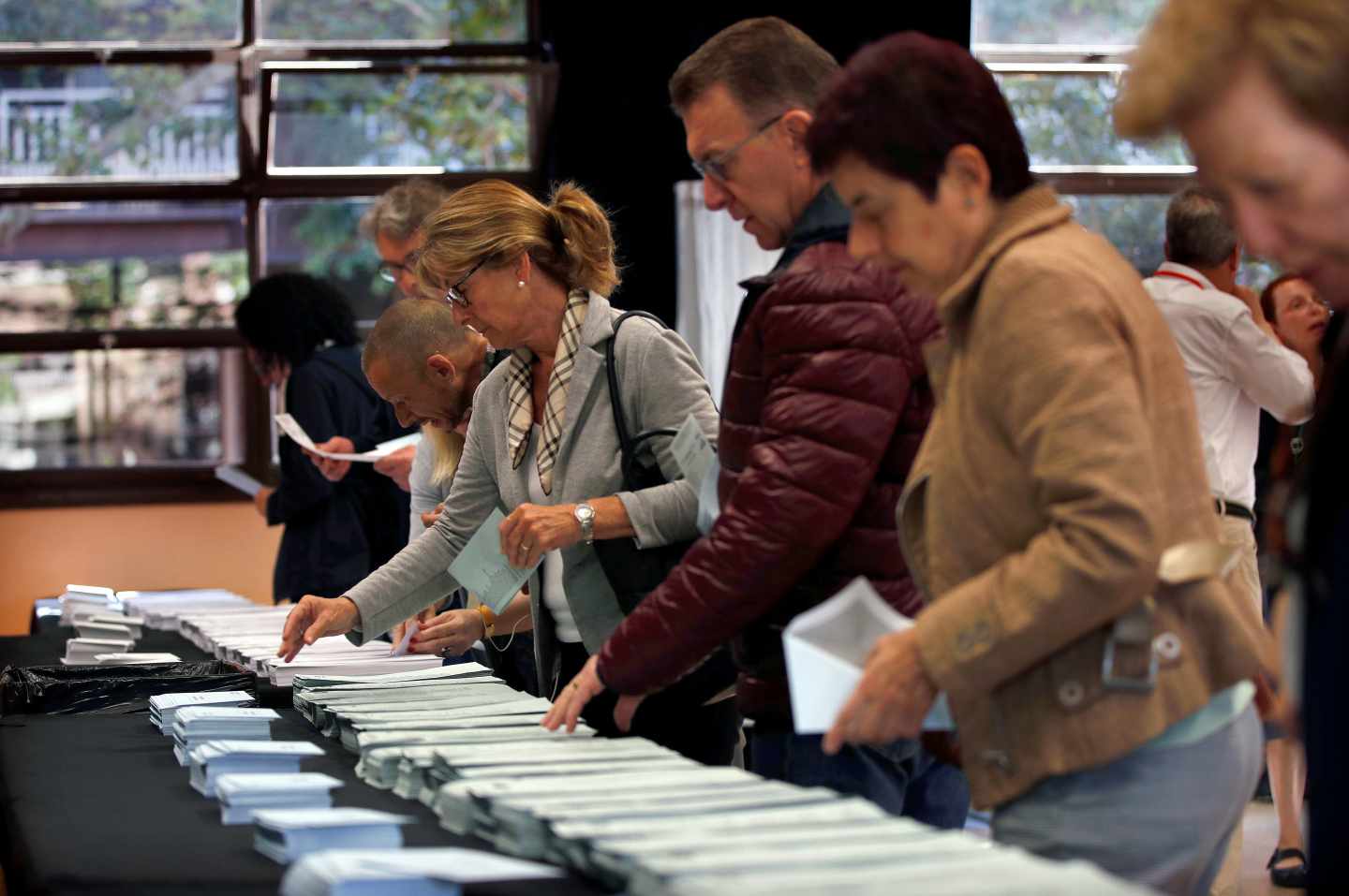 Varios ciudadanos escogen sus papeletas electorales en el Centre Cívic La Sedeta de Barcelona.