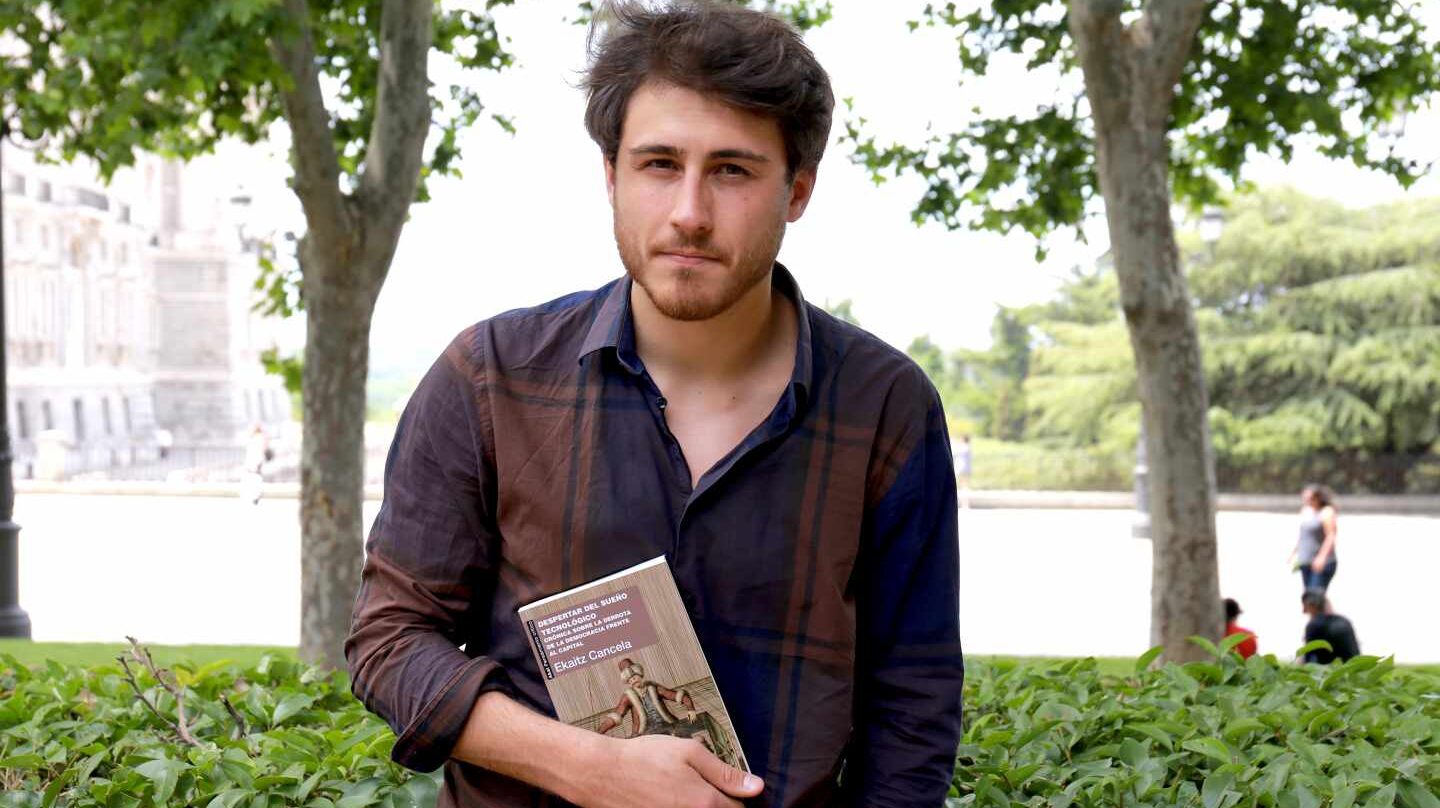Ekaitz Cancela sostiene su libro 'Despertar del sueño tecnológico' en la Plaza de Oriente de Madrid.