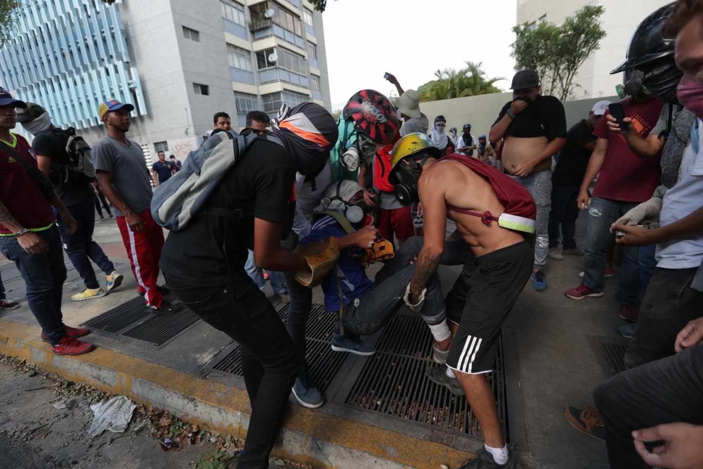 Manifestantes de la oposición ayudan a un herido en las marchas en Caracas.