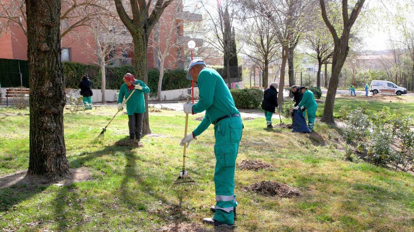 Empleados trabajando en la limpieza de un jardín público.