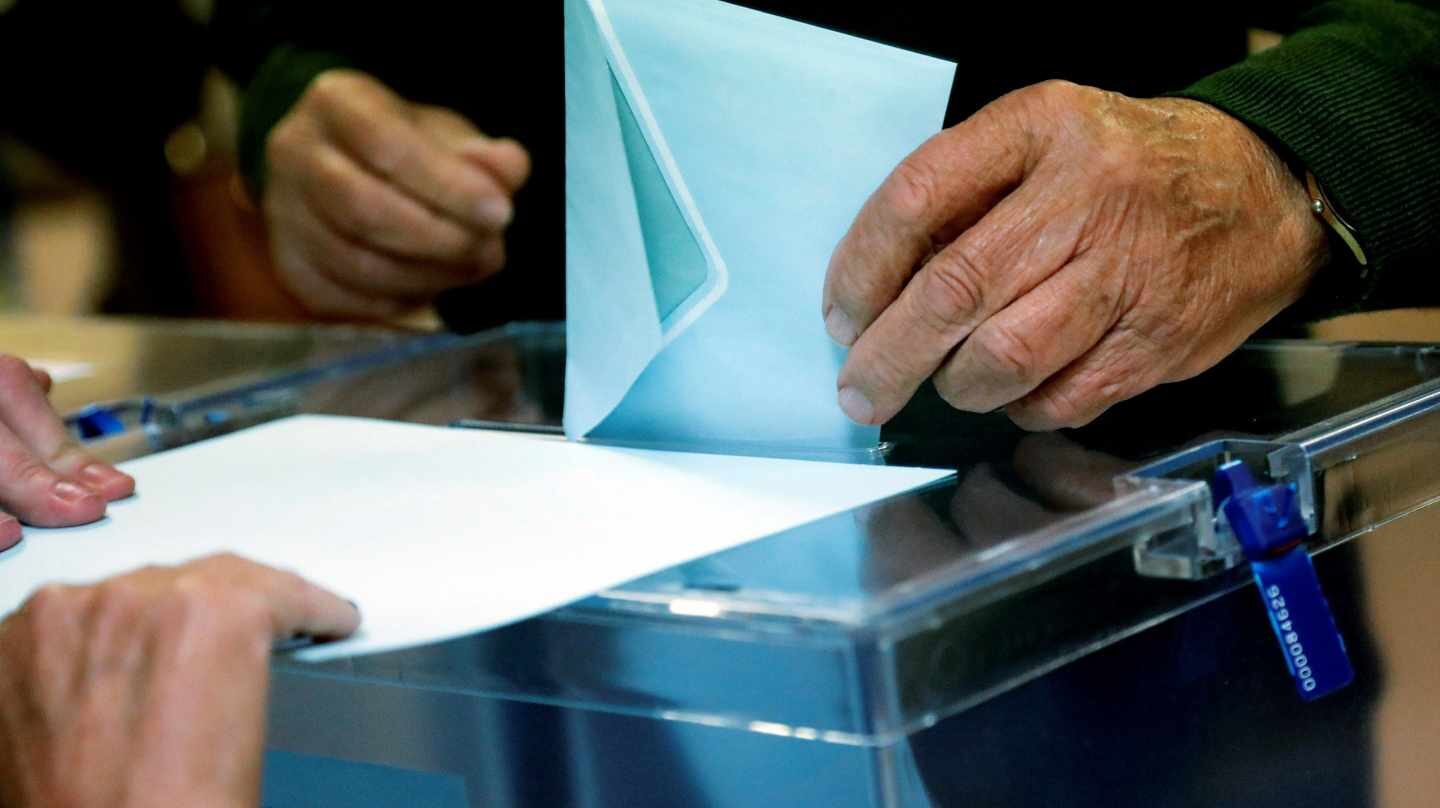 Un ciudadano deposita su voto ante la urna en Madrid.