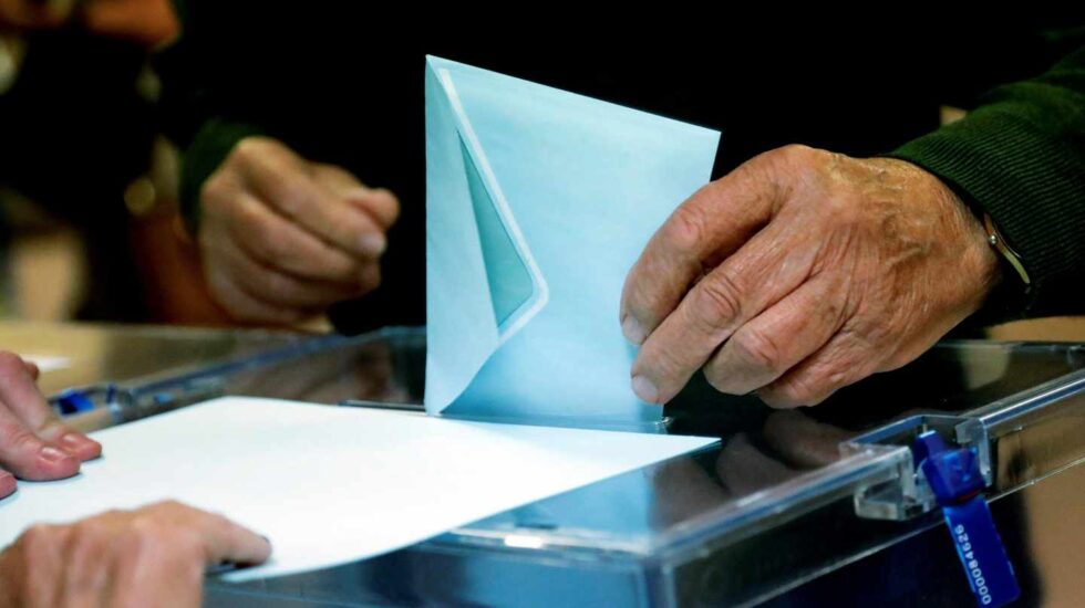 Un ciudadano deposita su voto ante la urna en Madrid.