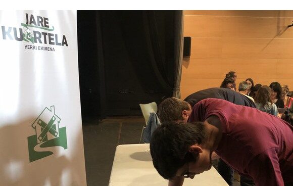 Un joven firma en una de las mesas instaladas por 'Jare Kuartela' contra la Guardia Civil en Oñati. Un joven firma en una de las mesas instaladas por 'Jare Kuartela'.