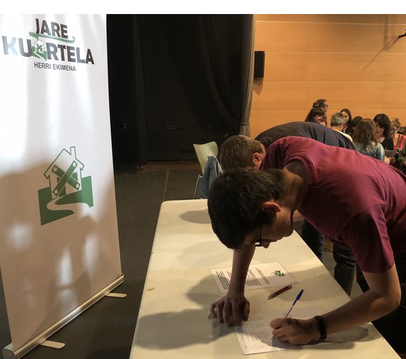 Un joven firma en una de las mesas instaladas por 'Jare Kuartela'.