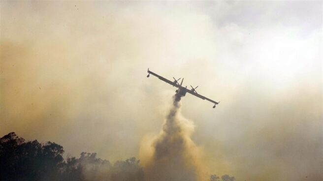 Un hidroavión descargando agua sobre un incendio.