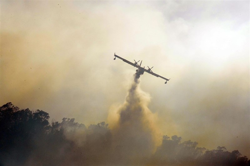 Un hidroavión descargando agua sobre un incendio.