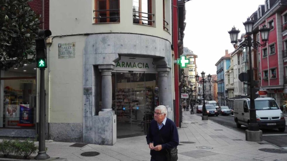 Un pensionista cruza frente a una Farmacia.