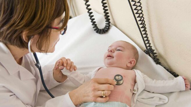 Una pediatra atendiendo a un bebé.