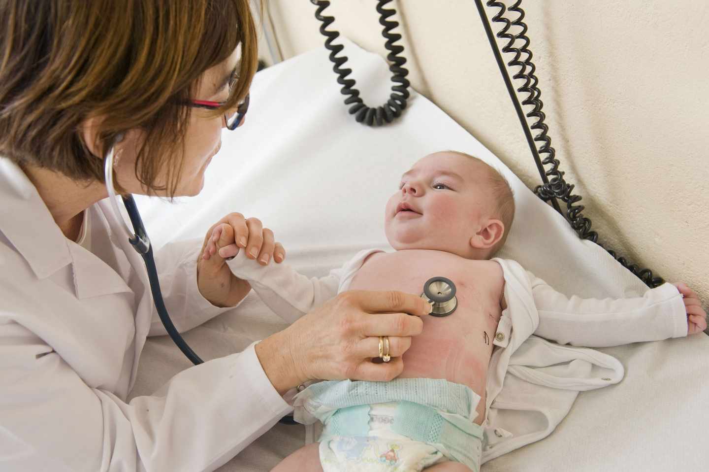 Una pediatra atendiendo a un bebé.