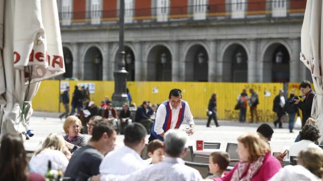 Un camarero sirve mesas en una terraza de Madrid.