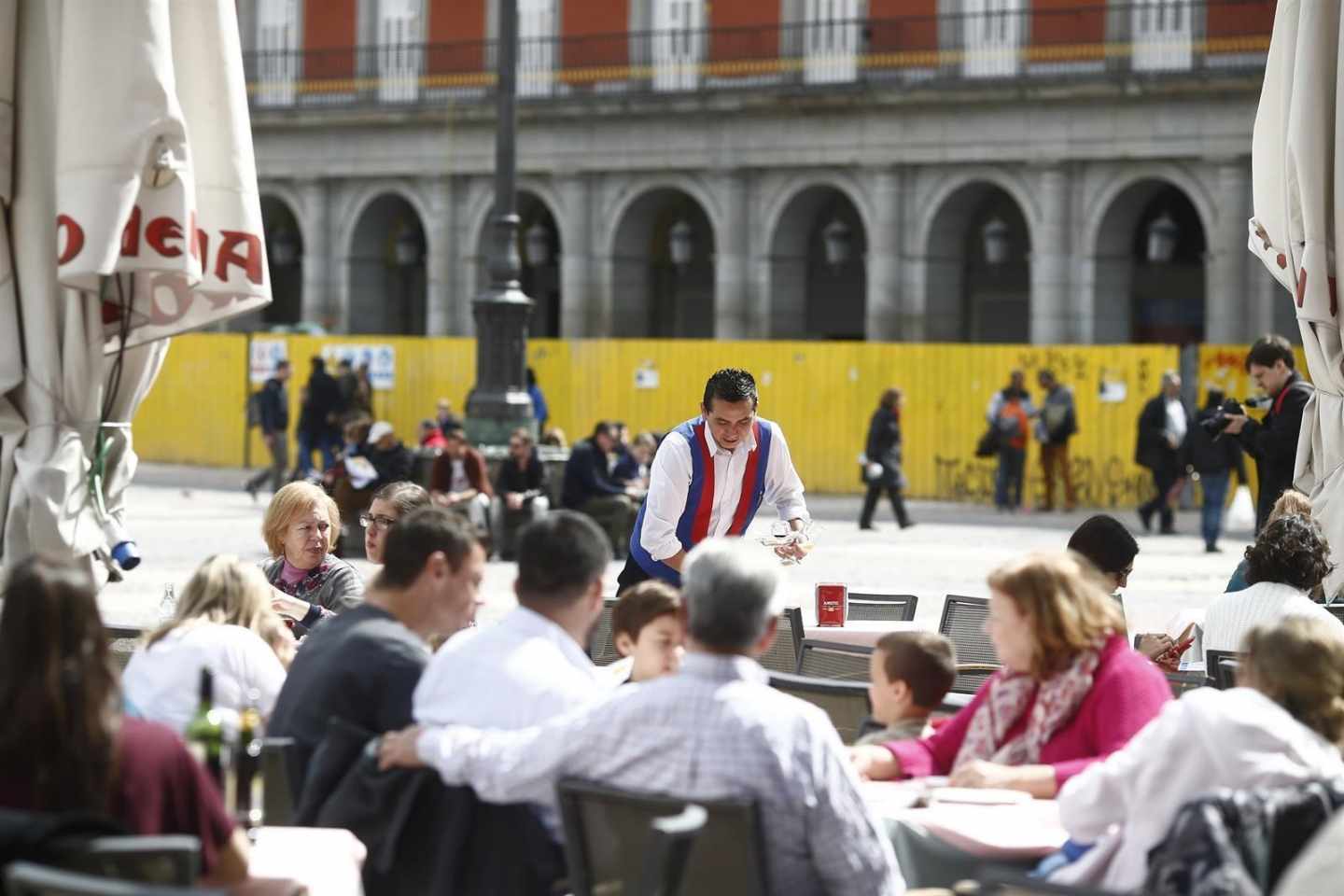 Un camarero sirve mesas en una terraza de Madrid.