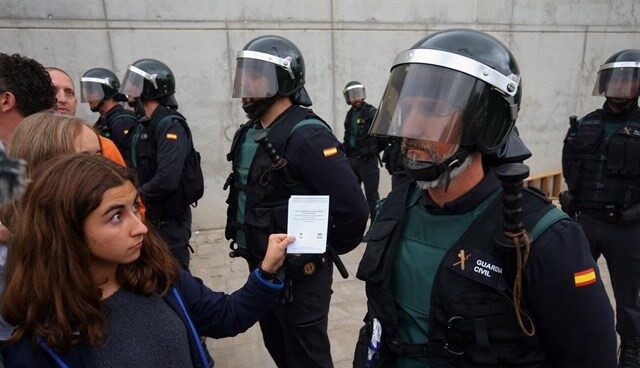 Un agente de la Guardia Civil frente a una votante durante el 1-O