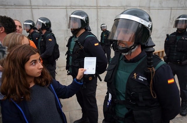 Un agente de la Guardia Civil frente a una votante durante el 1-O