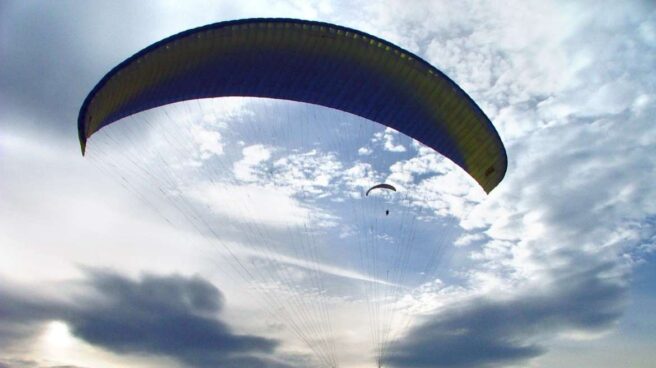 Una persona vuela en parapente Una persona vuela en parapente