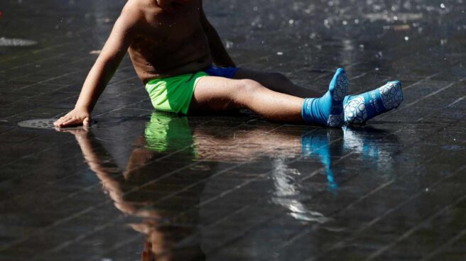 Un niño se refresca en los chorros de agua de la playa de Madrid Río.