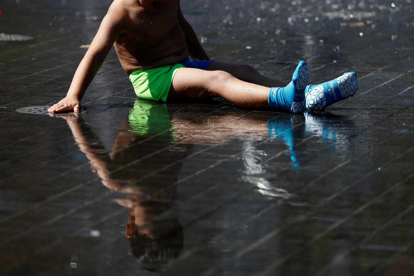 Un niño se refresca en los chorros de agua de la playa de Madrid Río.