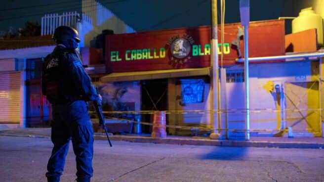 Un agente de la policía custodia en las primeras horas de este miércoles frente al bar El Caballo Blanco.