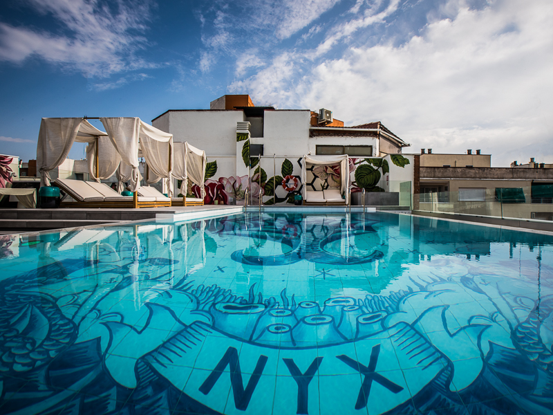 Piscina en Madrid en la terraza del Nyx Hotel, con camas balinesas y hamacas