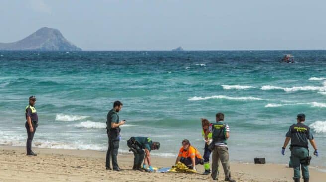 Agentes de la Guardia Civil y miembros de los servicios de Emergencias buscan restos del aparato siniestrado en una playa de la zona.