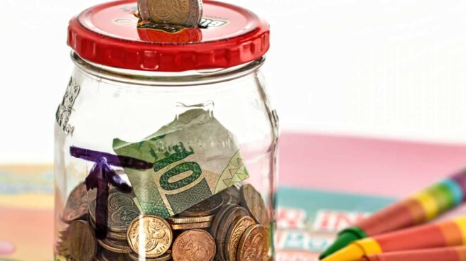 Dinero ahorro Monedas y billetes de euro en una hucha
