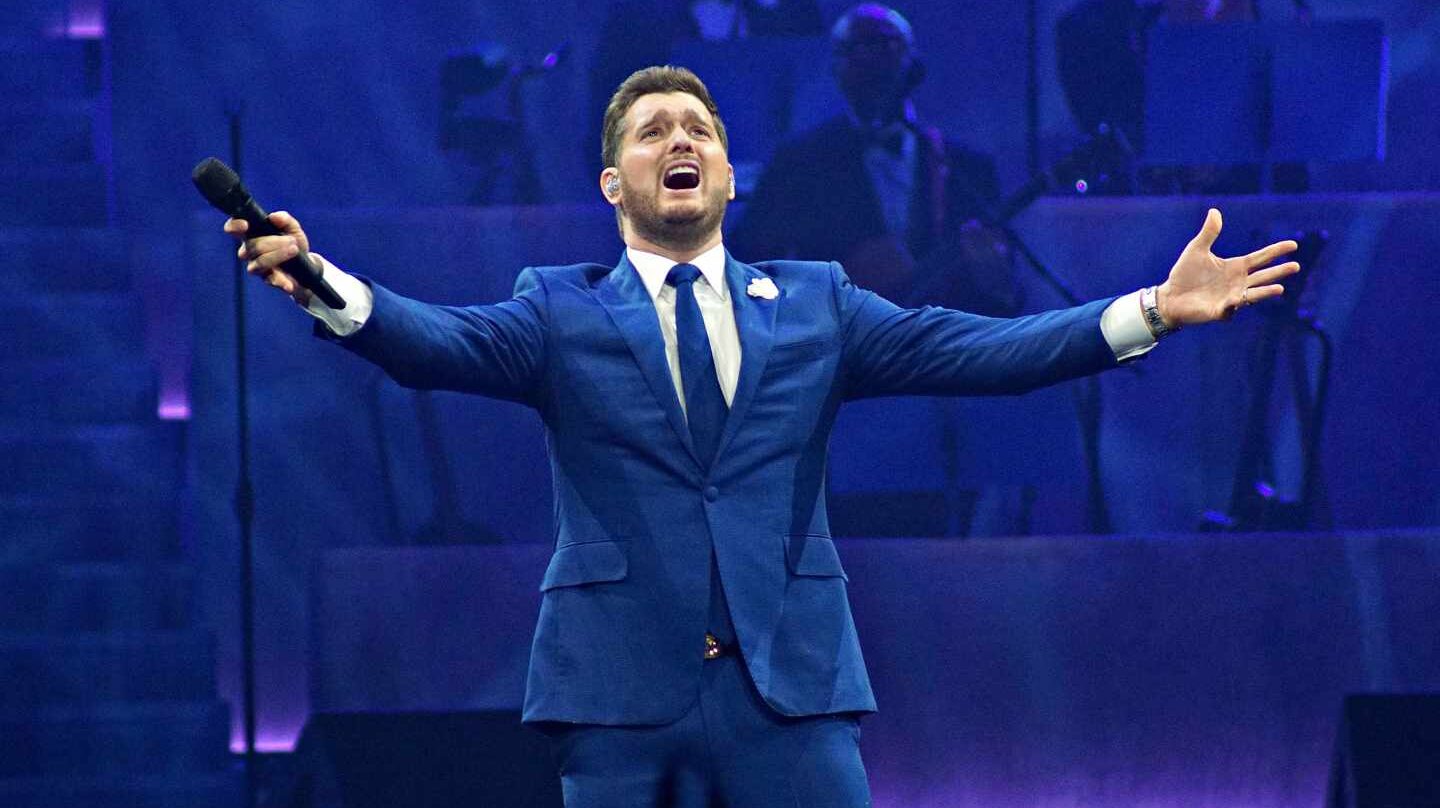 Michael Bublé con un traje azul cantando en un concierto