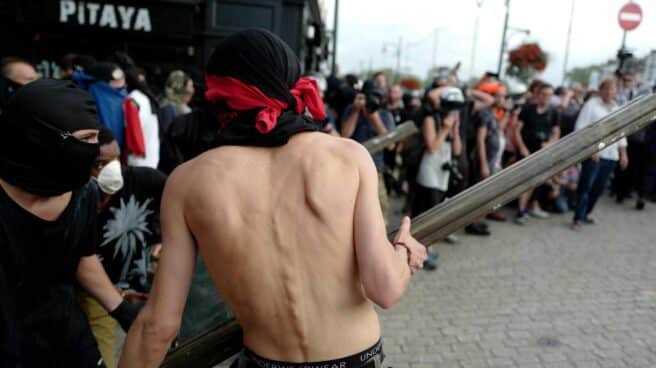 Encapuchados tratan de atacar a los gendarmes durante una manifestación contra el G-7 en Baiona.