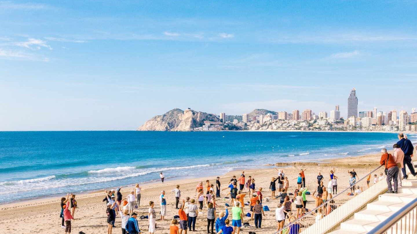 Un grupo de jubilados hace gimnasia en la playa, en Benidorm.
