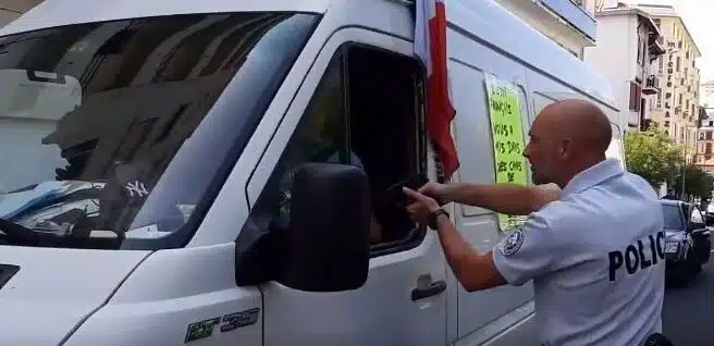 Un gendarme encañona al conductor de una furgoneta con mensajes contra el G-7