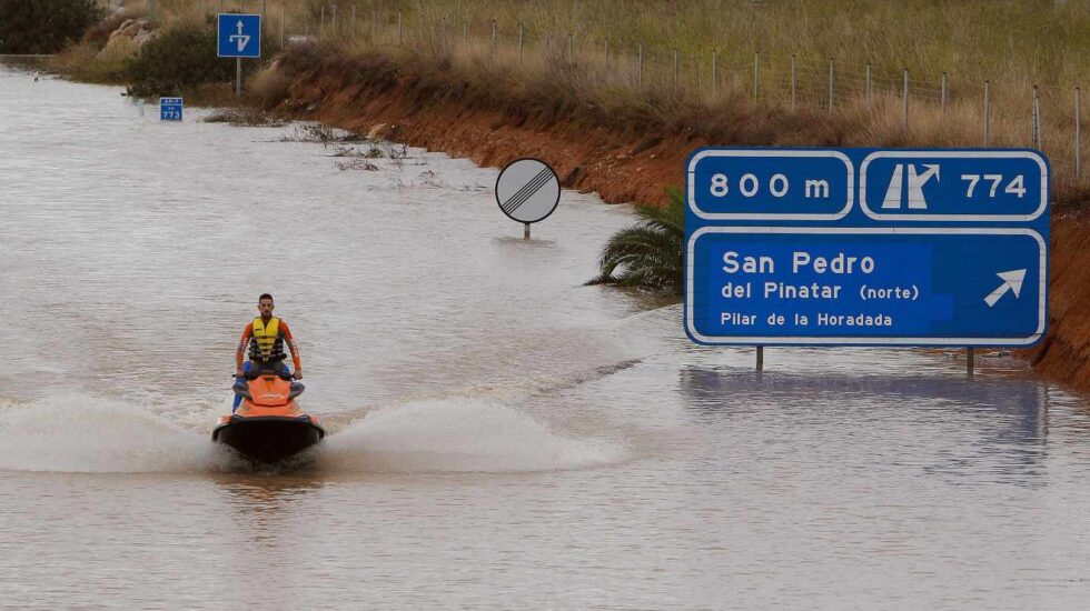 Un miembro de los servicios de rescate cruza la autopista AP-7 en moto acuática