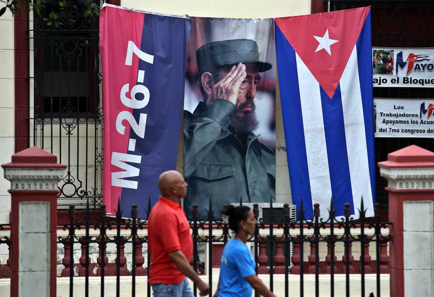 Dos cubanos pasan ante un gran cartel de Fidel en una conmemoración del Asalto al Cuartel Moncada.