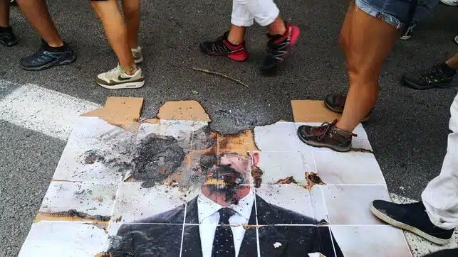 Los radicales independentistas queman una foto del Rey y de Macron en una marcha por la Diada