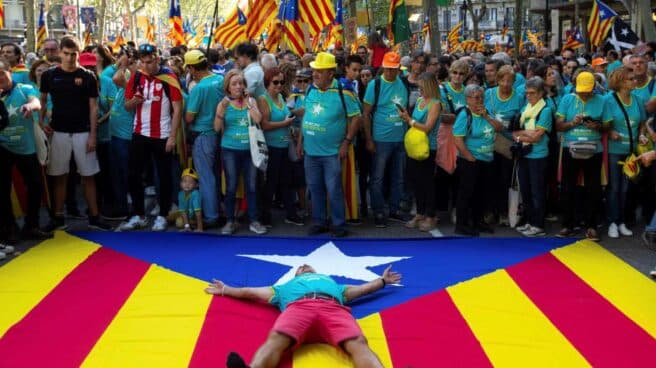 Un manifestante, tumbado sobre una estelada durante la Diada de 2019.