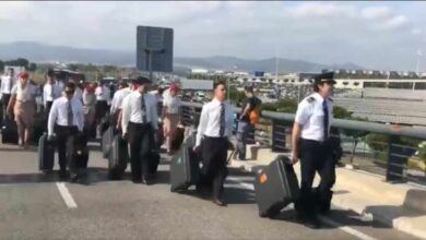 El personal de vuelo de Emirates accede a pie al aeropuerto del Prat por el bloqueo
