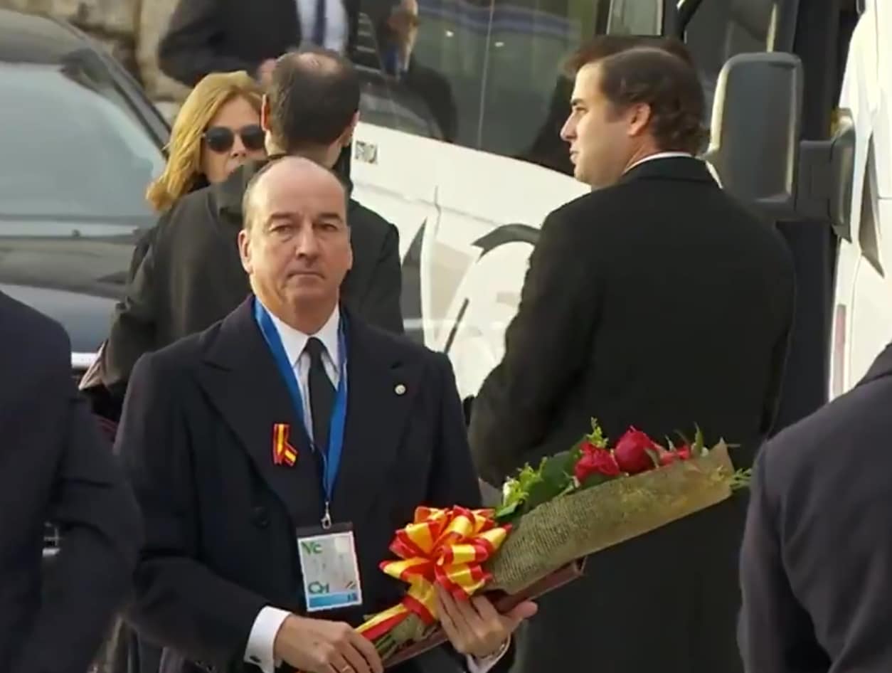 El abogado Luis Felipe Utrera-Molina, con el ramo de rosas rojas en las manos, antes de entrar en la basílica del Valle de los Caídos.