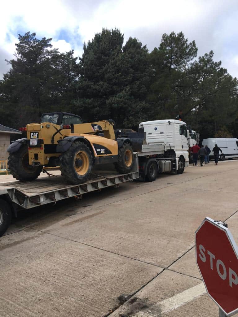 Un camión transporta una excavadora hasta el Valle de los Caídos.