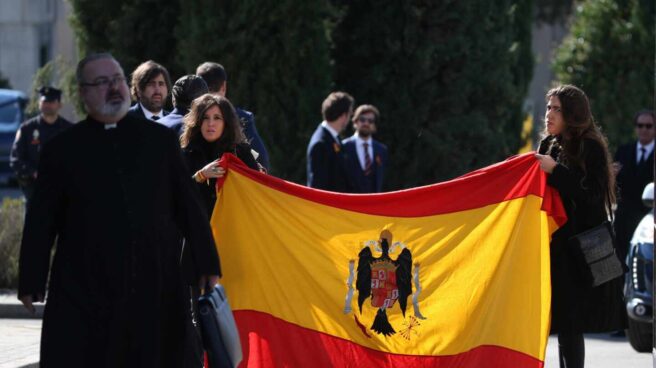 Dos bisnietas de Franco muestran la bandera preconstitucional tras el entierro del dictador en El Pardo.